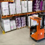 Workers operating a reach truck in a warehouse