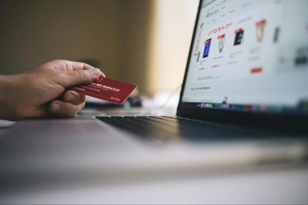 Man holding a credit card in front of E-Commerce website