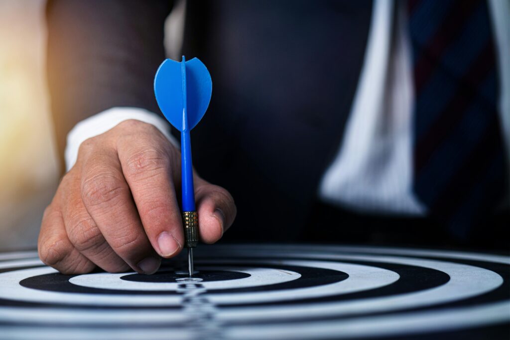 man pointing arrow to the center of dart board