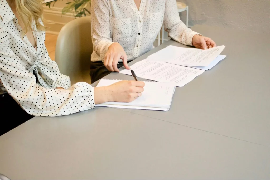 Two women discussing about a document