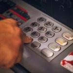 Man pressing a button in ATM