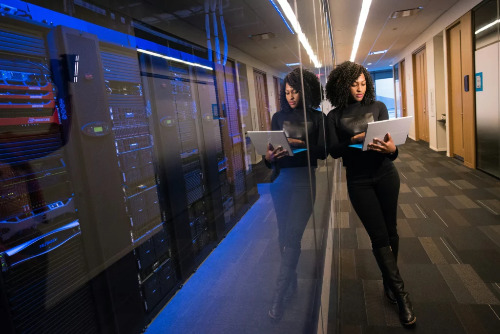 Woman carrying a laptop in a data center