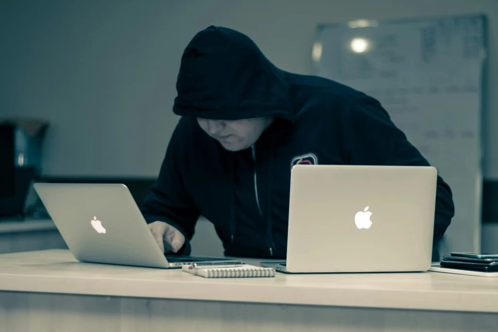 suspicious man working on MacBooks