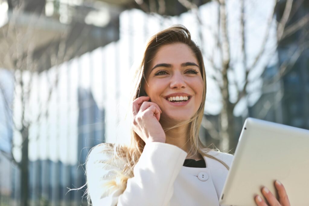 Woman is smiling while talking to someone on phone