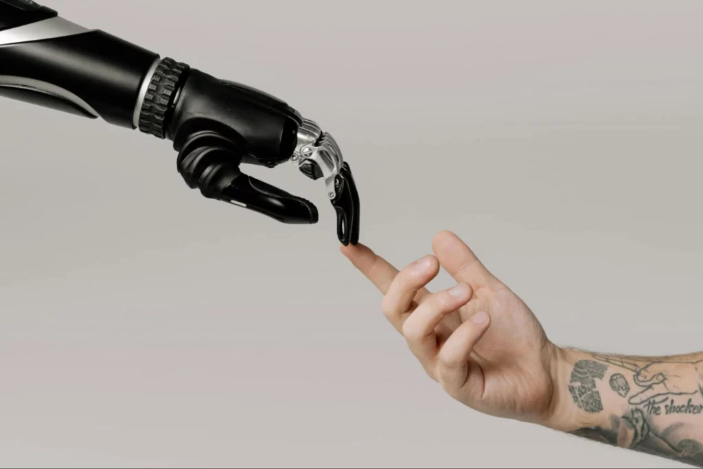 A robotic arm touches a human hand