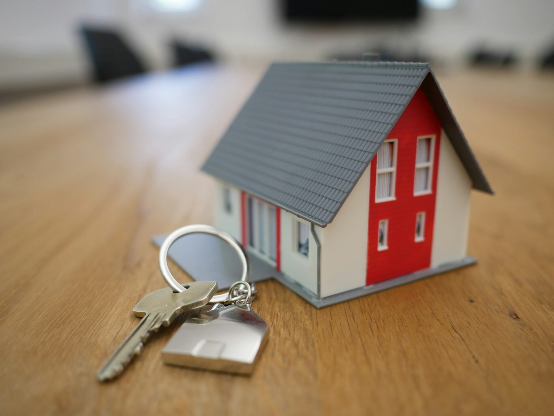 Keys kept beside of 3D model of a house